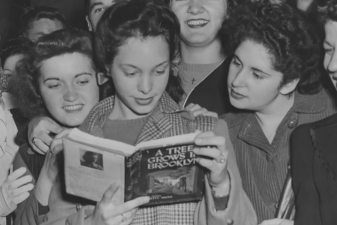 An image of Betty Smith and others looking at a novel.